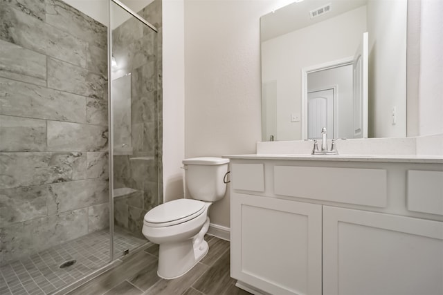 bathroom with walk in shower, vanity, and toilet