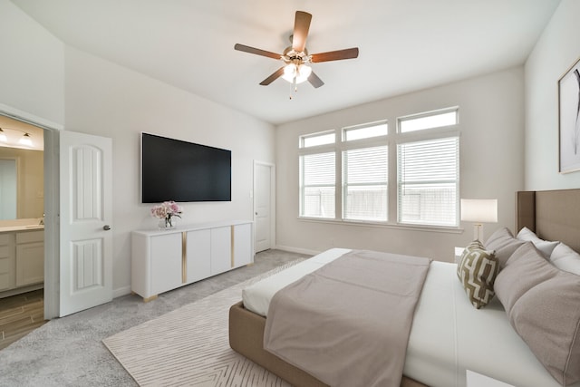 bedroom with connected bathroom, ceiling fan, and light hardwood / wood-style flooring