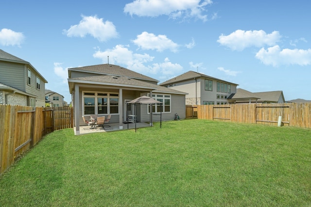 back of house with a yard and a patio