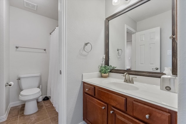 bathroom with tile patterned flooring, vanity, and toilet