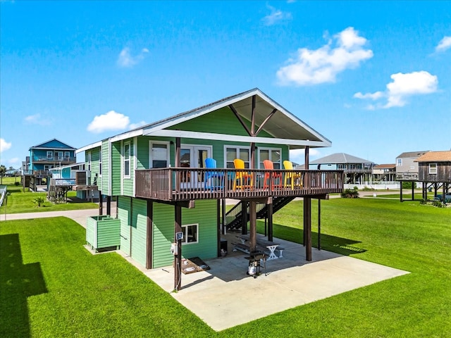 back of property with a lawn, a deck, and a patio