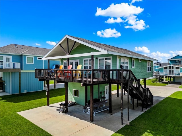 rear view of property with a wooden deck, a patio area, and a lawn