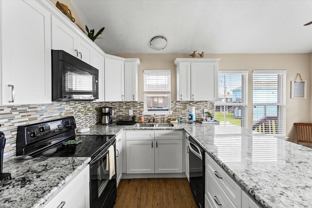 kitchen with tasteful backsplash, white cabinets, dark hardwood / wood-style flooring, black appliances, and sink