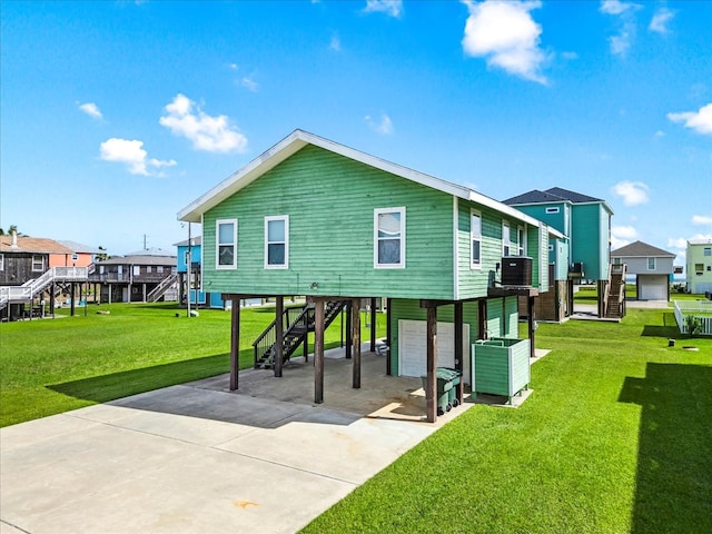 back of house featuring cooling unit, a garage, and a yard