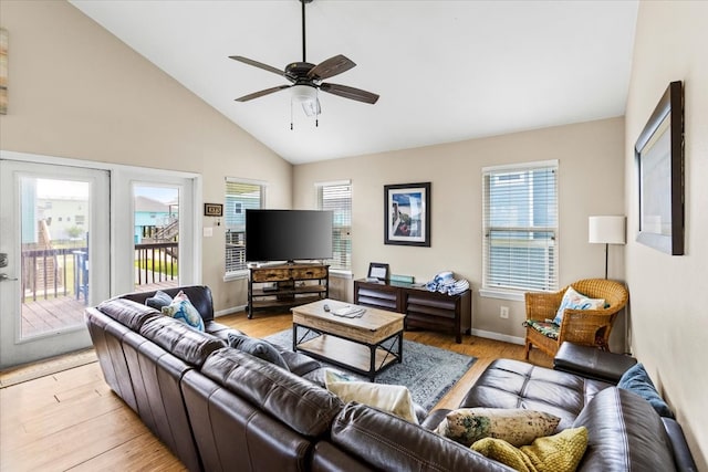 living room featuring ceiling fan, light wood-type flooring, high vaulted ceiling, and a healthy amount of sunlight