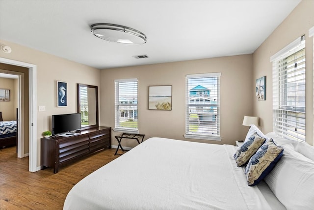 bedroom featuring multiple windows and hardwood / wood-style floors