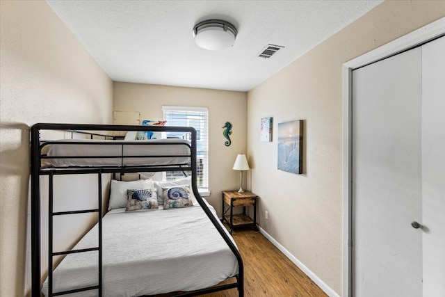 bedroom featuring a textured ceiling, hardwood / wood-style floors, and a closet