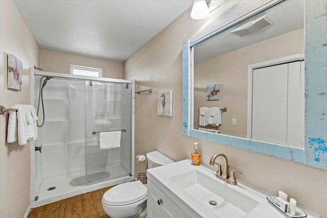 full bathroom with vanity, hardwood / wood-style flooring, toilet, and combined bath / shower with glass door