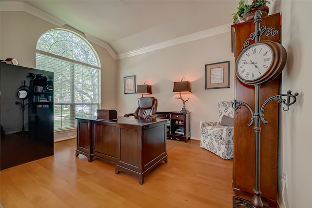 office space featuring a wealth of natural light, crown molding, lofted ceiling, and light wood-type flooring