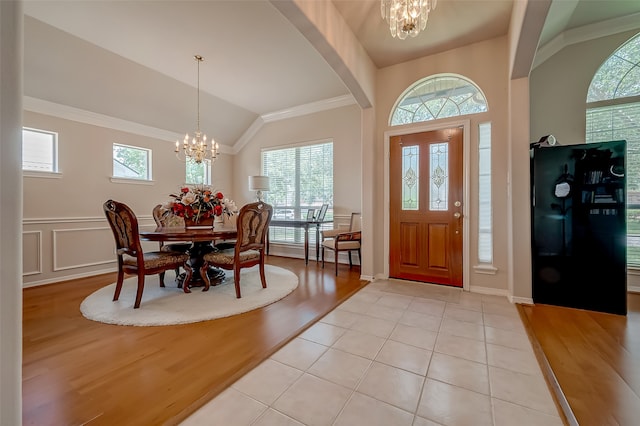 foyer with light hardwood / wood-style flooring, a healthy amount of sunlight, and a notable chandelier