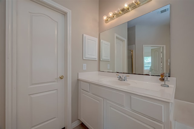 bathroom featuring vanity and a shower with door