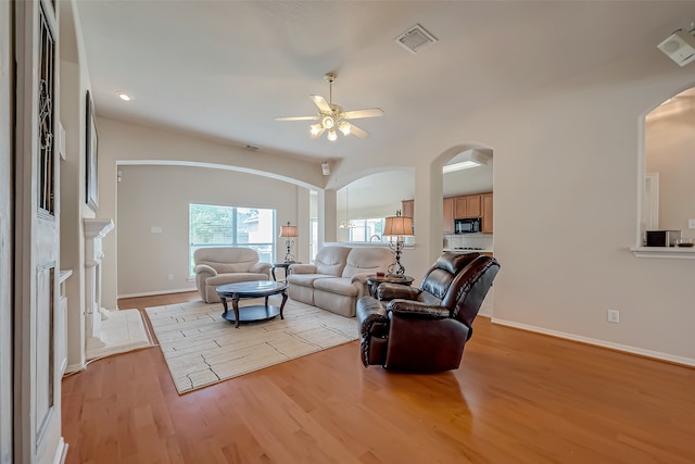 living room with ceiling fan and light hardwood / wood-style flooring