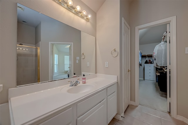 bathroom featuring tile patterned flooring, vanity, a shower with shower door, and vaulted ceiling