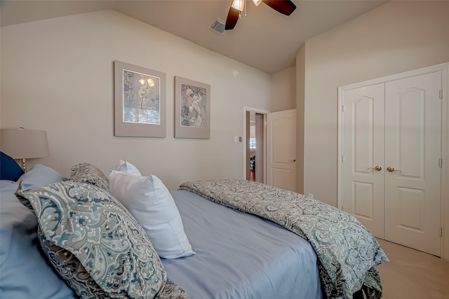 carpeted bedroom with a closet, vaulted ceiling, and ceiling fan