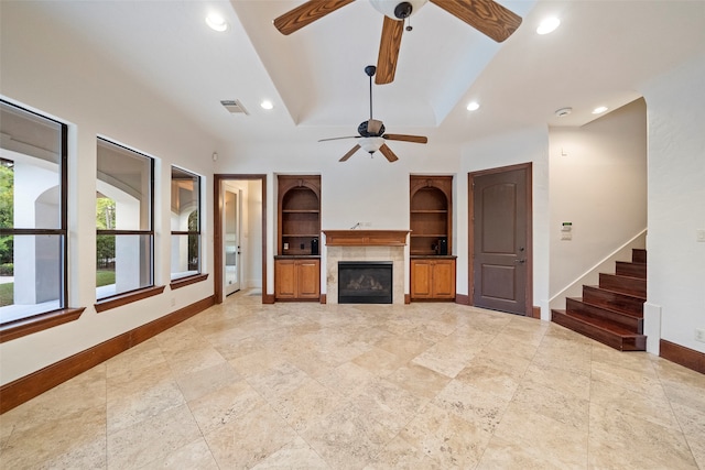 unfurnished living room featuring vaulted ceiling, ceiling fan, and a tile fireplace