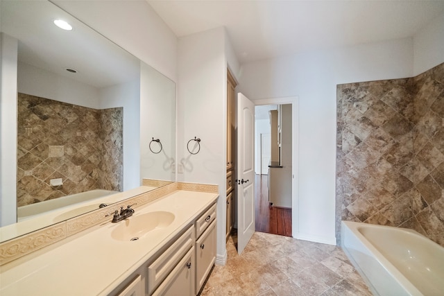 bathroom with vanity, tile walls, and a washtub