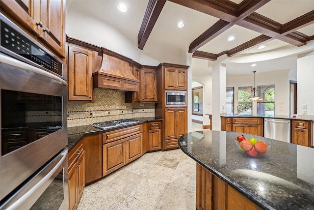 kitchen with dark stone counters, beamed ceiling, stainless steel appliances, and decorative light fixtures