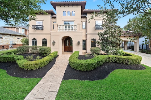 view of front of home featuring a front yard and a balcony