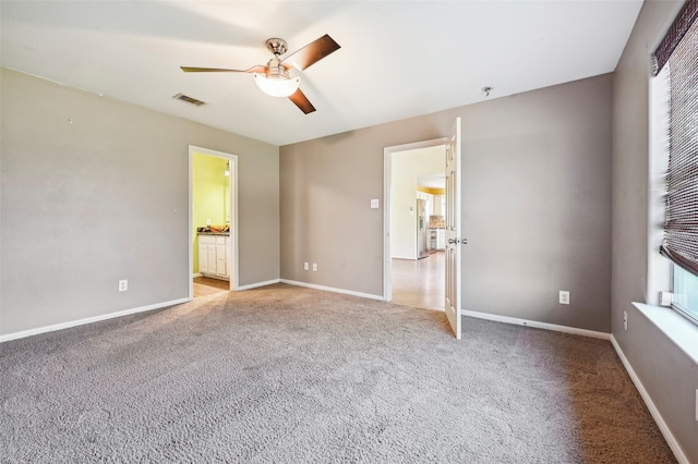 unfurnished bedroom featuring ceiling fan, connected bathroom, and light carpet