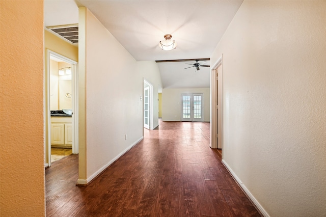 hallway with lofted ceiling, dark hardwood / wood-style floors, and french doors