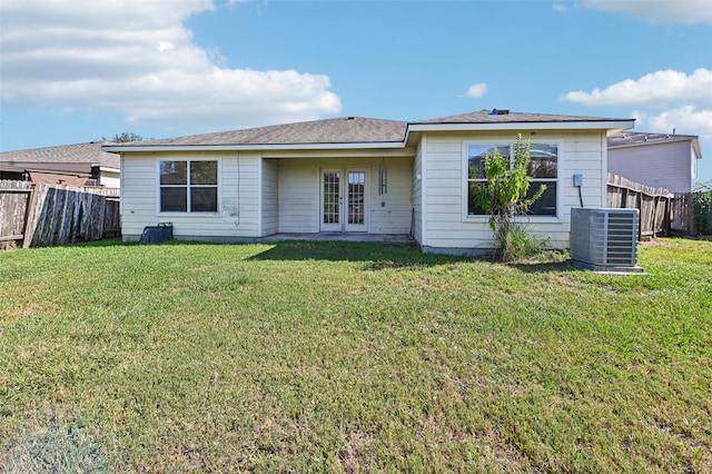 rear view of house with a yard and central air condition unit