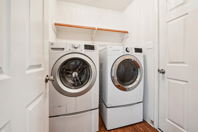 clothes washing area with washer and dryer and dark hardwood / wood-style flooring