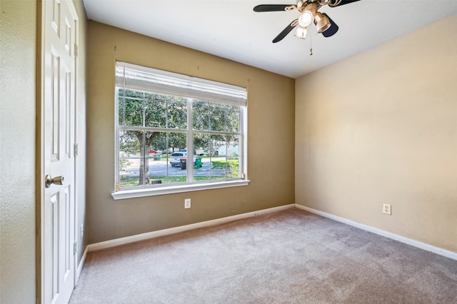 carpeted spare room featuring ceiling fan