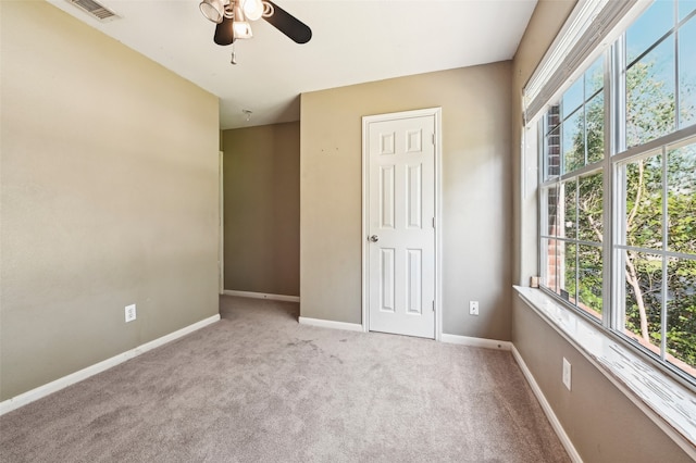 unfurnished room with ceiling fan and light carpet