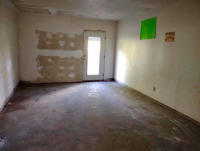 unfurnished room with a textured ceiling