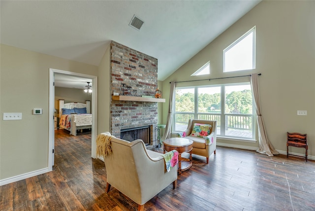 living room featuring high vaulted ceiling, a brick fireplace, ceiling fan, and dark wood-type flooring