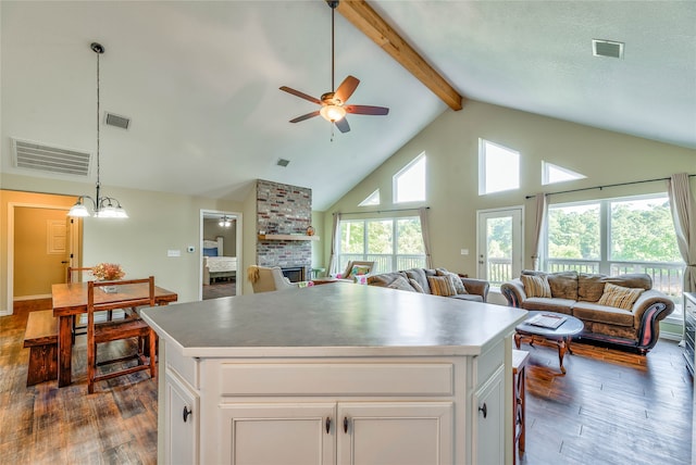 kitchen with a fireplace, white cabinetry, dark hardwood / wood-style flooring, and a center island