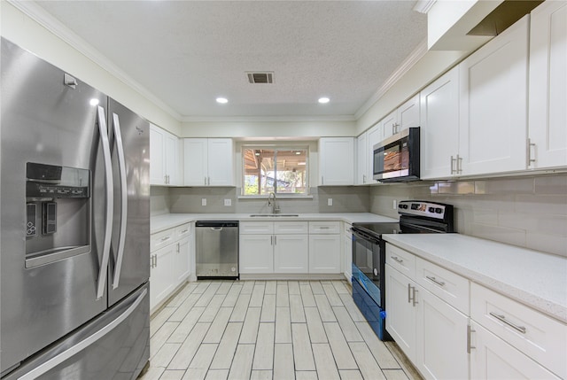 kitchen featuring sink, appliances with stainless steel finishes, a textured ceiling, and white cabinets