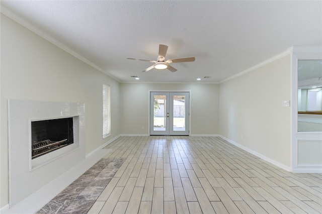 unfurnished living room with light wood-type flooring, french doors, a textured ceiling, ceiling fan, and ornamental molding