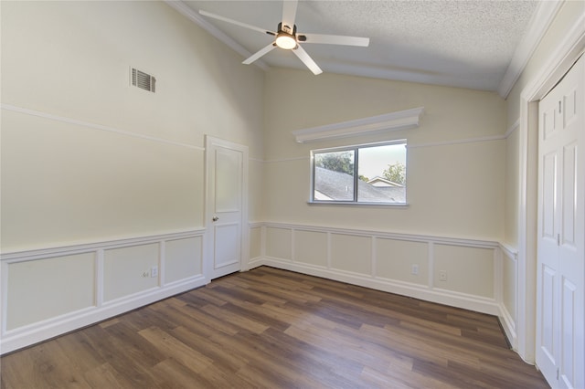 spare room with lofted ceiling, a textured ceiling, dark hardwood / wood-style floors, and ceiling fan