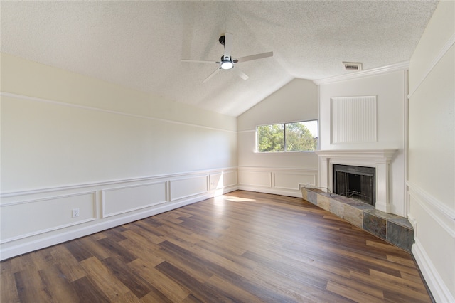 unfurnished living room with dark wood-type flooring, ceiling fan, a textured ceiling, and a tile fireplace