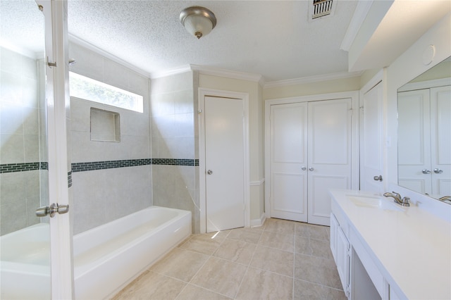 bathroom with a textured ceiling, tile patterned floors, tiled shower / bath, vanity, and crown molding