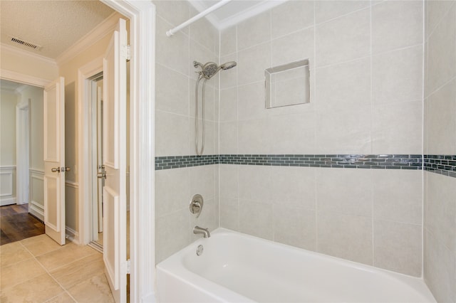 bathroom featuring tiled shower / bath, ornamental molding, a textured ceiling, and tile patterned floors