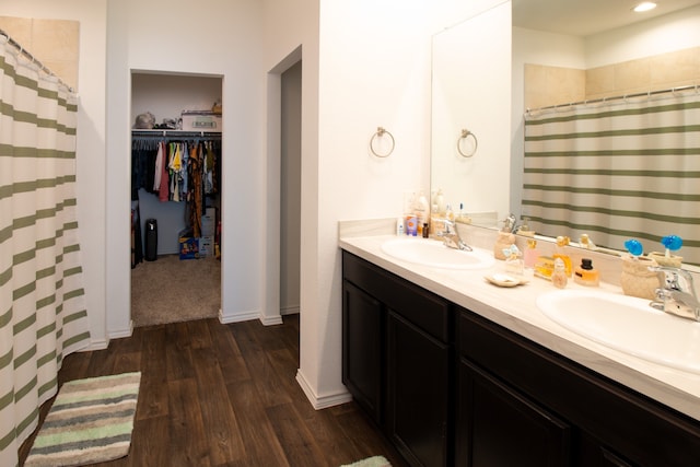 bathroom with wood-type flooring, vanity, and walk in shower