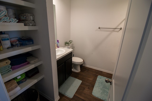 bathroom featuring vanity, toilet, and hardwood / wood-style flooring