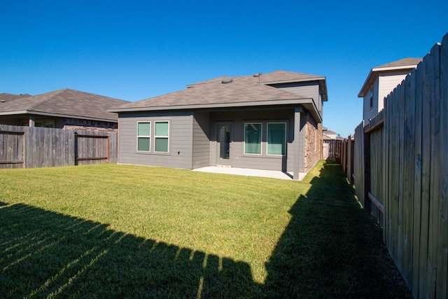 rear view of property with a patio area and a yard