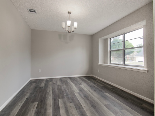 unfurnished room with dark hardwood / wood-style floors, a chandelier, and a textured ceiling