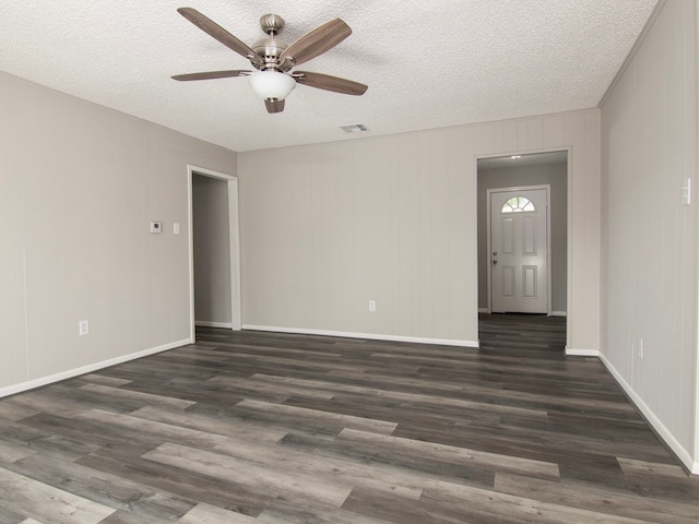 empty room with ceiling fan, a textured ceiling, and dark hardwood / wood-style flooring