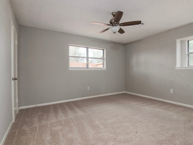 unfurnished room featuring a textured ceiling, carpet flooring, and ceiling fan