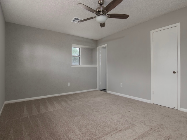 carpeted empty room featuring ceiling fan and a textured ceiling