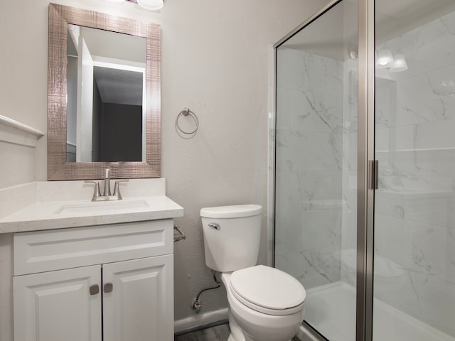 bathroom with toilet, vanity, and a shower with door