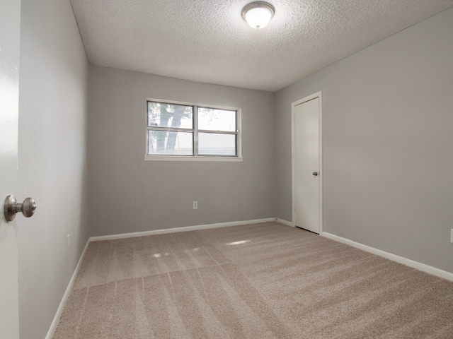 carpeted spare room featuring a textured ceiling