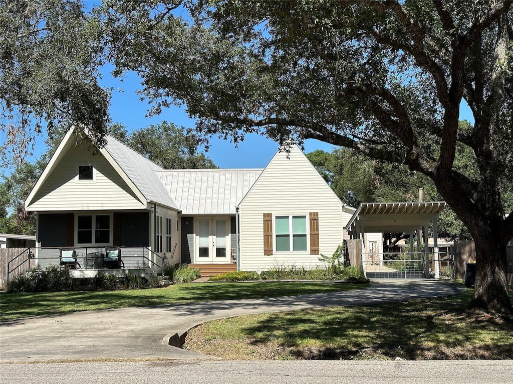 view of front of property featuring a carport, a porch, and a front yard