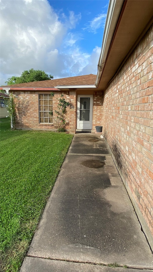 doorway to property with a yard