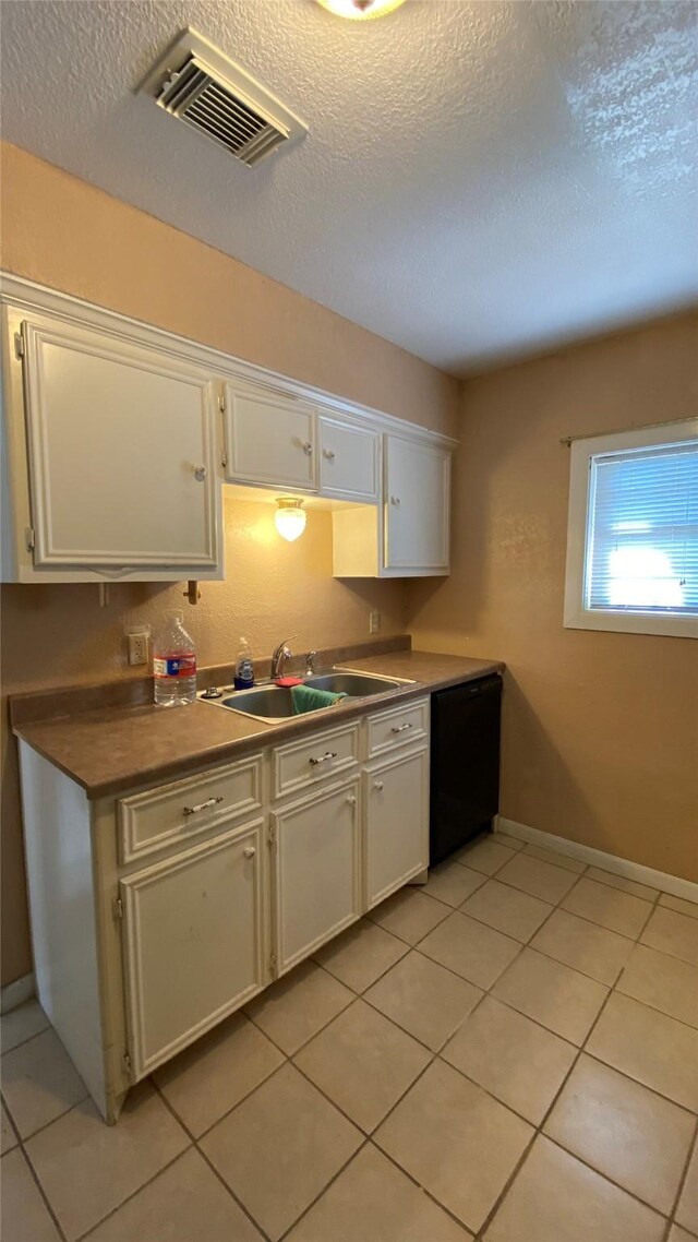 kitchen with black dishwasher, white cabinetry, and sink