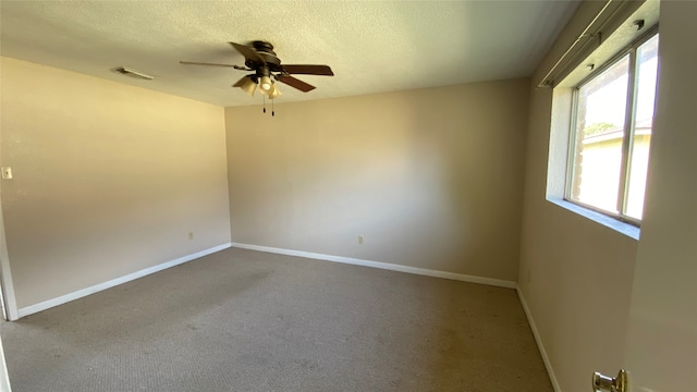 carpeted spare room with a textured ceiling and ceiling fan